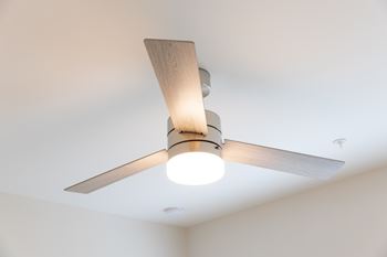 A ceiling fan with a light on in a room at The Crest at Oakwood Apartments, Oakwood 